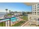 Balcony overlooking a community pool and beach, enhanced by a relaxing seating area for outdoor enjoyment at 2525 Gulf Of Mexico Dr # 3F, Longboat Key, FL 34228
