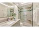 This bathroom features marble countertops and floors, updated fixtures, and a tiled glass-enclosed shower at 2525 Gulf Of Mexico Dr # 3F, Longboat Key, FL 34228