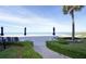 Charming walkway leading to the beach, with lush green landscaping and inviting beach chairs and umbrellas at 2525 Gulf Of Mexico Dr # 3F, Longboat Key, FL 34228
