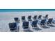 Chairs are on the beach with a view of the ocean and clear sky, perfect for relaxation and enjoyment at 2525 Gulf Of Mexico Dr # 3F, Longboat Key, FL 34228