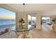 Bright dining area with a glass table and floor-to-ceiling window offering stunning ocean views and balcony access at 2525 Gulf Of Mexico Dr # 3F, Longboat Key, FL 34228
