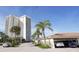 Exterior view of the Islands West complex, with a view of the building, carport, and tropical foliage at 2525 Gulf Of Mexico Dr # 3F, Longboat Key, FL 34228