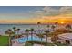 Relaxing pool area overlooking the beach at sunset, offering a tranquil escape with stunning ocean vistas and palm trees at 2525 Gulf Of Mexico Dr # 3F, Longboat Key, FL 34228