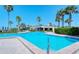 Community pool with beautiful landscaping and a clear view of the main building, perfect for relaxation and socializing at 2525 Gulf Of Mexico Dr # 3F, Longboat Key, FL 34228