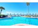 Beautiful beachfront pool with brick trim, complete with ocean views and blue patio umbrellas for comfortable lounging at 2525 Gulf Of Mexico Dr # 3F, Longboat Key, FL 34228