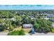 Aerial view of home nestled among mature trees with clear blue skies and a sense of neighborhood tranquility at 2538 Lakeshore Cir, Port Charlotte, FL 33952