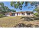 Backyard view of home, featuring a grassy lawn and simple architectural design at 2538 Lakeshore Cir, Port Charlotte, FL 33952