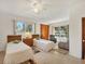 Bright bedroom with terrazzo floors, two twin beds, and two windows offering natural light at 2538 Lakeshore Cir, Port Charlotte, FL 33952