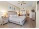 Well-lit bedroom with wood-look flooring, ceiling fan, and stylish furniture with a glimpse into the bathroom at 2715 Terra Ceia Bay Blvd # 504, Palmetto, FL 34221
