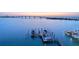 Aerial view of waterfront property with boat docks, bridge, and scenic skyline at sunset at 280 Golden Gate Pt # 600, Sarasota, FL 34236