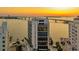 Stunning aerial view of a modern high-rise building near the water and a beautiful sunset at 280 Golden Gate Pt # 600, Sarasota, FL 34236