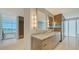 Bright bathroom with marble counters, double sinks, large mirrors, and a view at 280 Golden Gate Pt # 600, Sarasota, FL 34236