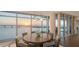 Elegant dining area with waterfront view, modern lighting, and seating for eight at 280 Golden Gate Pt # 600, Sarasota, FL 34236