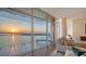 Modern living room with panoramic waterfront views and lounge chairs on the balcony at 280 Golden Gate Pt # 600, Sarasota, FL 34236