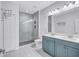 Bathroom featuring a double vanity with blue cabinets and frameless glass shower at 288 Crew Ct, Sarasota, FL 34243
