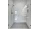 Modern glass shower features beautiful white tile with pebble flooring at 288 Crew Ct, Sarasota, FL 34243