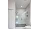 Modern glass shower features white tile with pebble flooring and built-in shelving at 288 Crew Ct, Sarasota, FL 34243