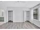 Bright bedroom featuring wood-look floors, ceiling fan, large walk-in closets, and ensuite bathroom at 288 Crew Ct, Sarasota, FL 34243