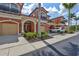 Attractive exterior view of a townhome with private garage and lush tropical landscaping at 288 Crew Ct, Sarasota, FL 34243