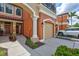 Inviting townhome showcasing an attached garage, front entryway and lush landscaping at 288 Crew Ct, Sarasota, FL 34243