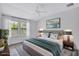 Cozy staged main bedroom featuring wood-look floors, ceiling fan, a window, and staged bed at 288 Crew Ct, Sarasota, FL 34243