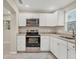 Modern kitchen features white cabinets, granite countertops, and stainless steel appliances at 2947 Goodrich Ave, Sarasota, FL 34234