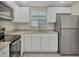 Modern kitchen with stainless steel appliances, granite countertops, and white cabinetry at 2947 Goodrich Ave, Sarasota, FL 34234