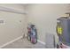 Utility room with a shelf, stack of paint cans, and water heater at 2947 Goodrich Ave, Sarasota, FL 34234