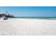 Wide sandy beach with a calming scene of people relaxing near the clear ocean waters at 2950 Clark Rd # 113, Sarasota, FL 34231