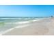 Tranquil beach scene with gentle waves and distant cityscape offering a serene coastal lifestyle at 2950 Clark Rd # 113, Sarasota, FL 34231