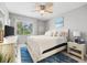 Bright bedroom featuring a queen bed, blue rug, and light wood furniture at 2950 Clark Rd # 113, Sarasota, FL 34231