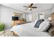 Bedroom features large bed with gray and white accents and ceiling fan at 2950 Clark Rd # 113, Sarasota, FL 34231