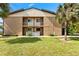 Two-story building with balconies overlooking a green lawn and mature palm trees offering curb appeal at 2950 Clark Rd # 113, Sarasota, FL 34231