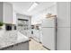 Bright, well-equipped kitchen featuring white cabinetry, granite countertops, and stainless-steel appliances at 2950 Clark Rd # 113, Sarasota, FL 34231