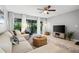 Cozy living room with modern furnishings, neutral tones, ceiling fan, and access to outdoor patio at 2950 Clark Rd # 113, Sarasota, FL 34231