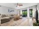 Bright living room featuring a large sectional sofa, stylish rug, ceiling fan, and sliding glass doors at 2950 Clark Rd # 113, Sarasota, FL 34231