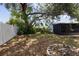 Backyard featuring a fire pit, a large shade tree, and a partially screened patio at 3505 27Th W Ave, Bradenton, FL 34205