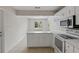 Bright kitchen featuring tile floors, bar seating, and white appliances at 3505 27Th W Ave, Bradenton, FL 34205