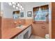 Vintage bathroom featuring pink tiling, ample vanity space, and natural lighting at 4311 52Nd E St, Bradenton, FL 34208