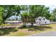 Spacious homes are on a large lot with mature trees, a driveway, and a white fence at 4311 52Nd E St, Bradenton, FL 34208