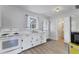 Cozy kitchen with white cabinetry, laminate flooring, and a sink beneath a window, offering a bright and functional space at 4311 52Nd E St, Bradenton, FL 34208