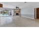 Open living room with terrazzo flooring, a stone fireplace, and sliding glass doors to pool at 4311 52Nd E St, Bradenton, FL 34208
