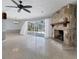 Open living room with polished floors and stone fireplace, leading to screened patio at 4311 52Nd E St, Bradenton, FL 34208