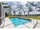 Sparkling pool surrounded by a screened enclosure and ample deck space with a view of mature trees at 4311 52Nd E St, Bradenton, FL 34208