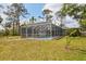 Expansive grassy yard featuring a screened pool enclosure and mature trees at 4311 52Nd E St, Bradenton, FL 34208
