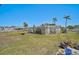 Backyard featuring green space, palm trees, a fire pit, and a pergola, perfect for entertaining at 4420 101St W St, Bradenton, FL 34210