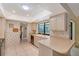 Bright kitchen features tiled floors, neutral cabinetry, skylight and a view of the backyard at 4609 Talbot Pl, Sarasota, FL 34241