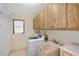 Well-lit laundry room features a washer, utility sink, and plenty of storage cabinets at 4609 Talbot Pl, Sarasota, FL 34241