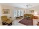 Sunlit living area with neutral tones, showcasing a cozy sofa, stylish rug, and large windows with blinds at 4609 Talbot Pl, Sarasota, FL 34241