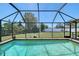 Sparkling swimming pool is encased in screen, surrounded by a patio and lush landscaping at 4609 Talbot Pl, Sarasota, FL 34241